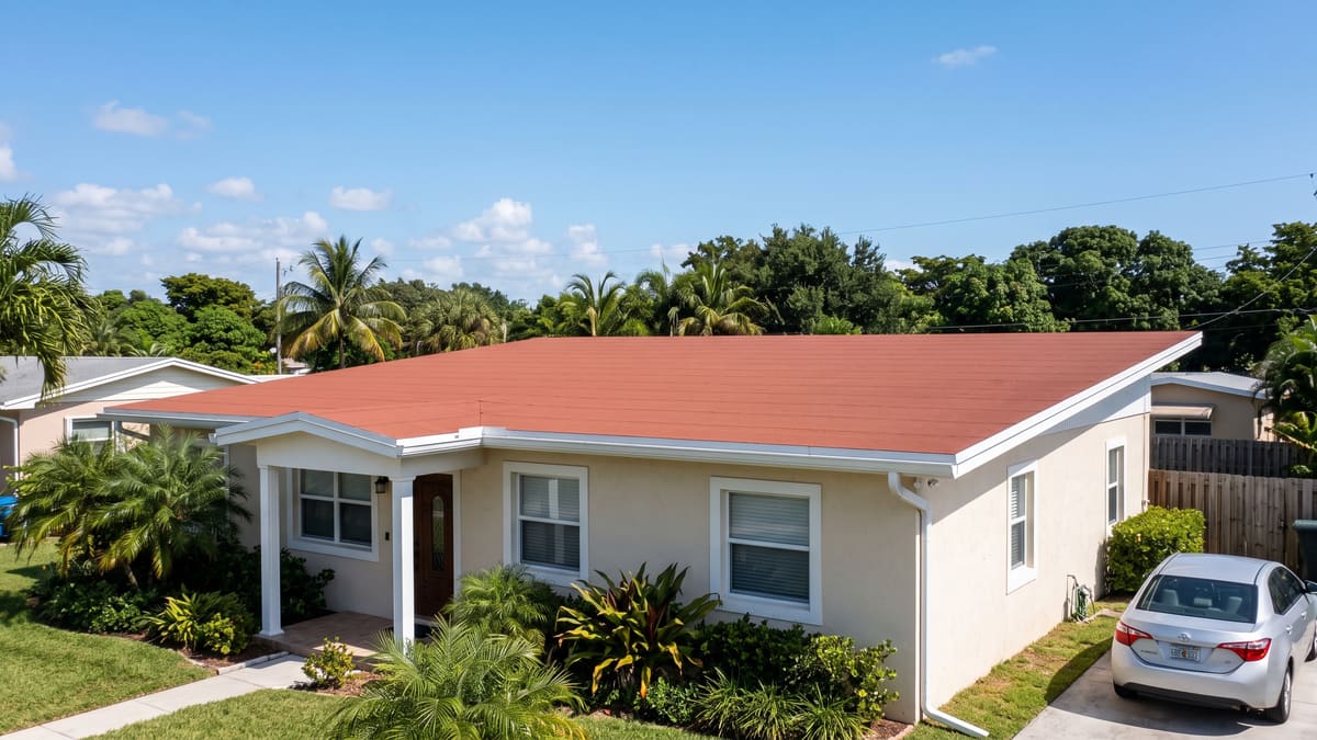 Red low-slope flat roof on a single-story Florida stucco home